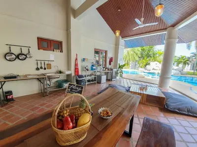 a living room with a table with a basket of fruit at Coconut Wells Phuket in Chalong
