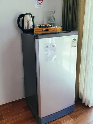 a refrigerator in a room with a table on top of it at Coconut Wells Phuket in Chalong