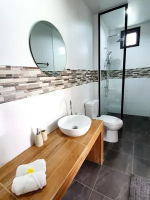 a bathroom with a sink and a toilet and a mirror at Coconut Wells Phuket in Chalong