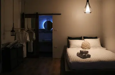 a bedroom with a bed with a stuffed animal on it at Coconut Wells Phuket in Chalong