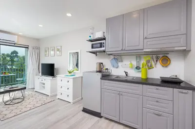 a kitchen with white cabinets and a sink at NaiYang beach Title Residencies by My Home Phuket in Nai Yang Beach