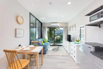 a kitchen and living room with a table and chairs at NaiYang beach Title Residencies by My Home Phuket in Nai Yang Beach