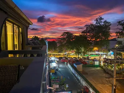 a view of a city at sunset from a balcony at Big Boys' Bed & Burger - Patong Beach in Patong Beach