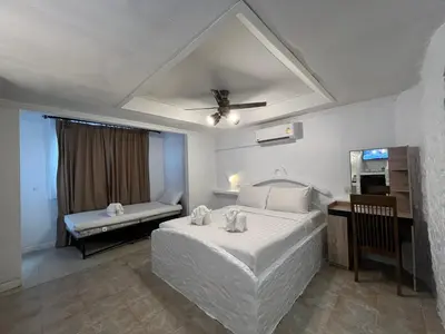 a bedroom with a white bed and a desk at Big Boys' Bed & Burger - Patong Beach in Patong Beach