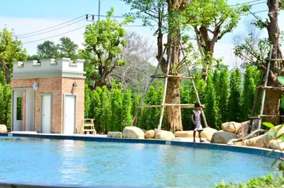 a woman is standing next to a swimming pool at The Title Residence NaiYang in Nai Yang Beach