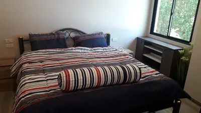 a bed with a striped comforter in a bedroom at The Title Residence NaiYang in Nai Yang Beach