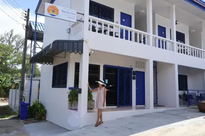 a woman standing outside of a white building at Sun & Sea Nai Yang Phuket in Nai Yang Beach