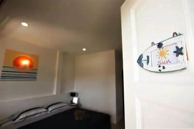 a room with a door with a clock on the wall at Sun & Sea Nai Yang Phuket in Nai Yang Beach