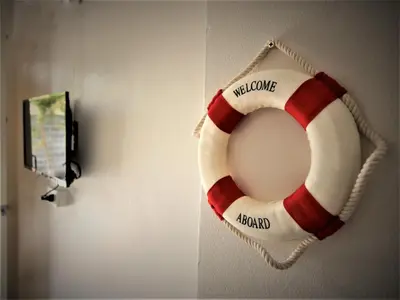 a red and white life preserver hanging on a wall at Sun & Sea Nai Yang Phuket in Nai Yang Beach