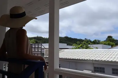 a person in a hat sitting on a porch looking out the window at Sun & Sea Nai Yang Phuket in Nai Yang Beach