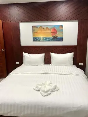 a bed with two white towels sitting on it at Easy Loft Hostel in Phuket Town