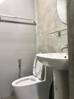 a bathroom with a white toilet and a sink at Easy Loft Hostel in Phuket Town