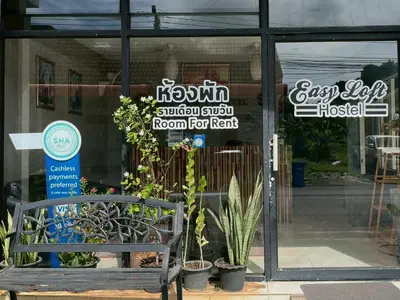 a storefront with a bench in front of a window at Easy Loft Hostel in Phuket Town