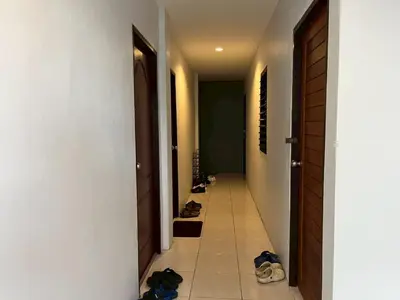 a row of shoes are lined up in a hallway at Easy Loft Hostel in Phuket Town
