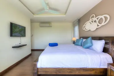 a bedroom with a large white bed with blue pillows at 5bdr Pool Villa In Laguna Park #45 by Capital Pro in Bang Tao Beach
