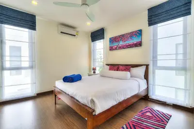 a bedroom with a bed and two windows at 5bdr Pool Villa In Laguna Park #45 by Capital Pro in Bang Tao Beach