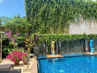 a swimming pool with plants and flowers in a yard at Phi Phi Maiyada Resort in Phi Phi Don