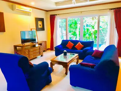 a living room with blue couches and a tv at Thai Family karon Pool Villa \u6cf0\u5982\u5bb6\u5361\u4f263\u5367\u6cf3\u6c60\u522b\u5885 in Karon Beach