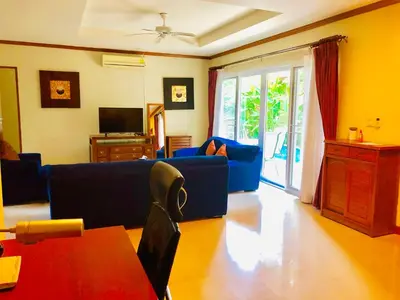 a living room with a blue couch and a tv at Thai Family karon Pool Villa \u6cf0\u5982\u5bb6\u5361\u4f263\u5367\u6cf3\u6c60\u522b\u5885 in Karon Beach