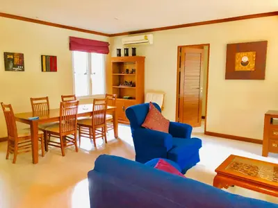a living room with a blue couch and a table and chairs at Thai Family karon Pool Villa \u6cf0\u5982\u5bb6\u5361\u4f263\u5367\u6cf3\u6c60\u522b\u5885 in Karon Beach