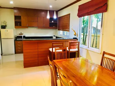 a kitchen with a wooden table and a refrigerator at Thai Family karon Pool Villa \u6cf0\u5982\u5bb6\u5361\u4f263\u5367\u6cf3\u6c60\u522b\u5885 in Karon Beach