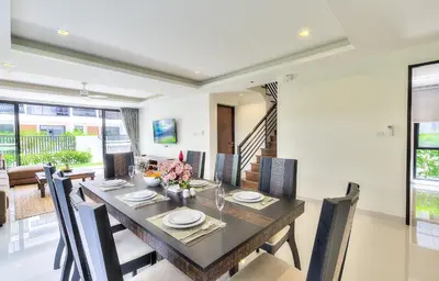 a dining room with a long table and chairs at 5bdr Pool Villa In Laguna Park #40 by Capital Pro in Bang Tao Beach