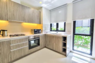 a kitchen with wooden cabinets and a large window at 5bdr Pool Villa In Laguna Park #40 by Capital Pro in Bang Tao Beach