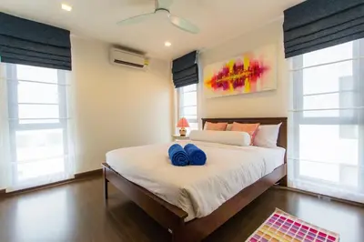 a bedroom with a bed with two blue shoes on it at 5bdr Pool Villa In Laguna Park #40 by Capital Pro in Bang Tao Beach