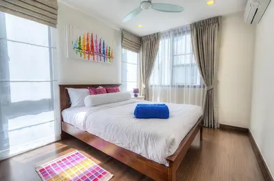 a bedroom with a bed with a blue pillow on it at 5bdr Pool Villa In Laguna Park #40 by Capital Pro in Bang Tao Beach