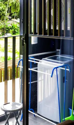 a washer and dryer on a porch with a table and a stool at The Aristo by Holy Cow, studio, mountain view in Surin Beach