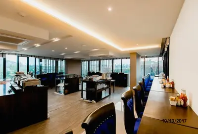 a restaurant with a long table and blue chairs at The Aristo by Holy Cow, studio, mountain view in Surin Beach