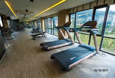 a row of treadmills in a gym with windows at The Aristo by Holy Cow, studio, mountain view in Surin Beach