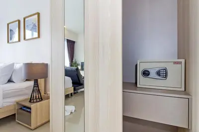 a room with a bed and a television on a table at Chic Condo by RESAVA in Karon Beach