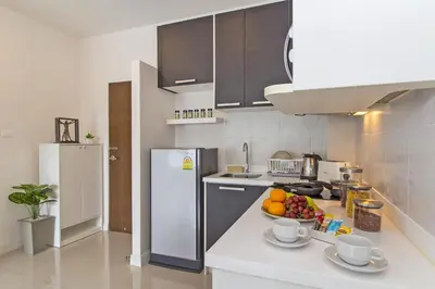 a kitchen with a bowl of fruit on a counter at Chic Condo by RESAVA in Karon Beach