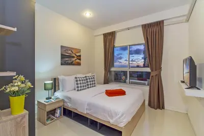 a bedroom with a bed and a window at Chic Condo by RESAVA in Karon Beach
