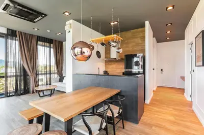 a kitchen and dining room with a wooden table and chairs at Lucky Holidays in Saturdays Residence in Rawai Beach