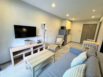 a living room with a couch and a tv at The Title Residencies Naiyang by Beringela in Nai Yang Beach