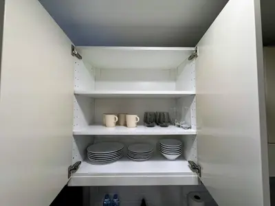 a pantry with white shelves with plates and cups at The Title Residencies Naiyang by Beringela in Nai Yang Beach