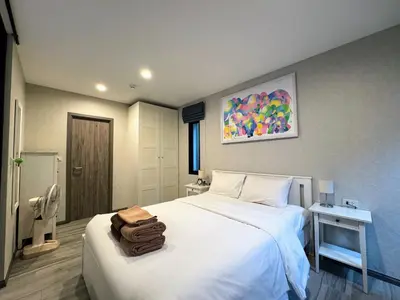 a bedroom with a bed with a bag on it at The Title Residencies Naiyang by Beringela in Nai Yang Beach