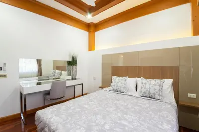 a bedroom with a bed and a desk at Rudi House in Patong Beach