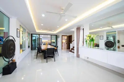 a dining room with a table and a ceiling fan at Rudi House in Patong Beach