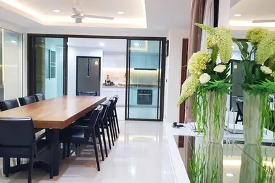 a dining room with a wooden table and black chairs at Rudi House in Patong Beach