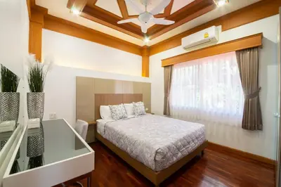 a bedroom with a bed and a ceiling fan at Rudi House in Patong Beach