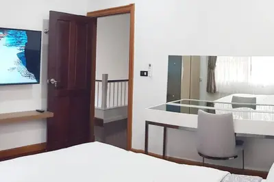 a hotel room with a bed and a tv and a room at Rudi House in Patong Beach