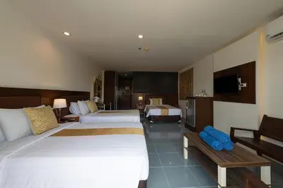 a hotel room with two beds and a television at Blue Beach Grand Resort And Spa in Rawai Beach