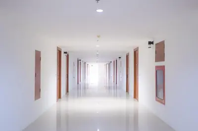 an empty hallway with white walls and wooden doors at Blue Beach Grand Resort And Spa in Rawai Beach