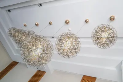 a group of spheres hanging from a ceiling at Apartment at Aristo Surin by Lofty in Surin Beach