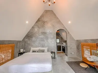 a bedroom with a white bed and an attic at Baan Rai Me Rak Organic Farmstay in Ban Pa Khlok
