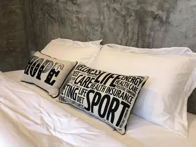 a bed with two pillows on top of it at Baan Rai Me Rak Organic Farmstay in Ban Pa Khlok