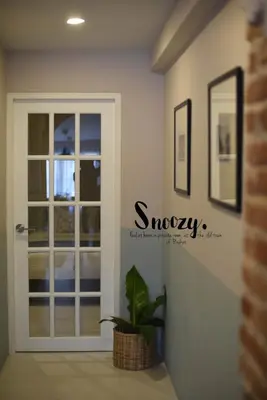 a door in a room with a plant next to it at Snoozy Guesthouse in Phuket Town
